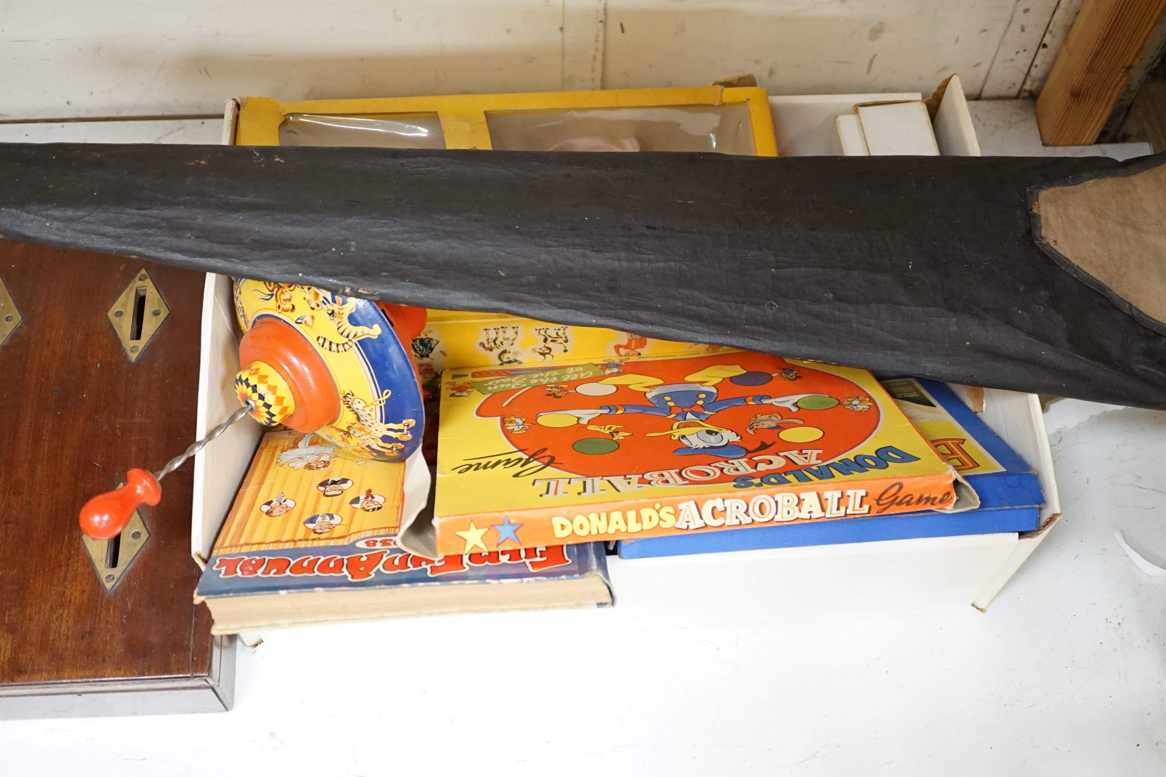 An early 20th century cased Bussey’s Hawk kite, a black walkie talkie doll, a four slot money box, an early Pelham puppet and two others, a hump backed teddy, together with various games and soft toys